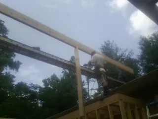 Carpenter setting a ridge beam over a new addition frame — Ice Dam Removal by Roofing Brothers in Trivoli