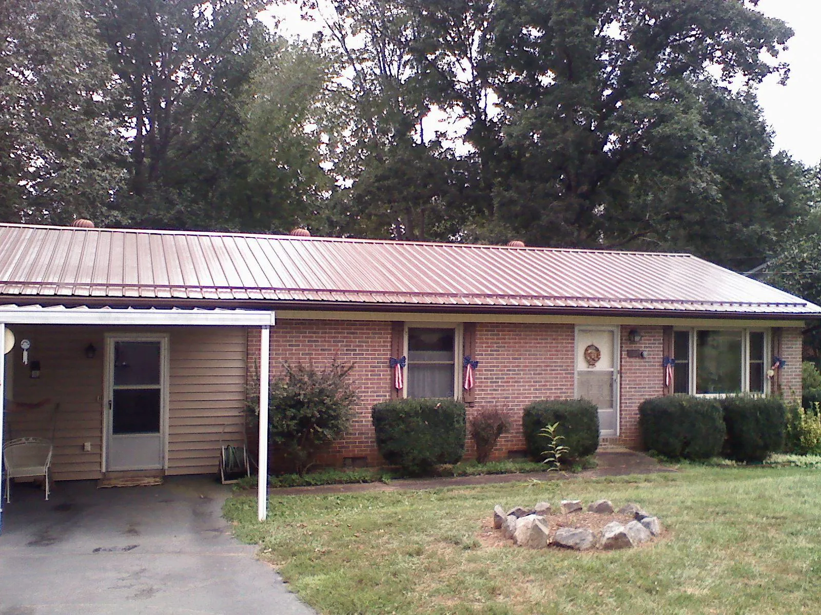 Bronze metal roof and carport on a brick ranch home — Roof Repair work by our crew in Trivoli